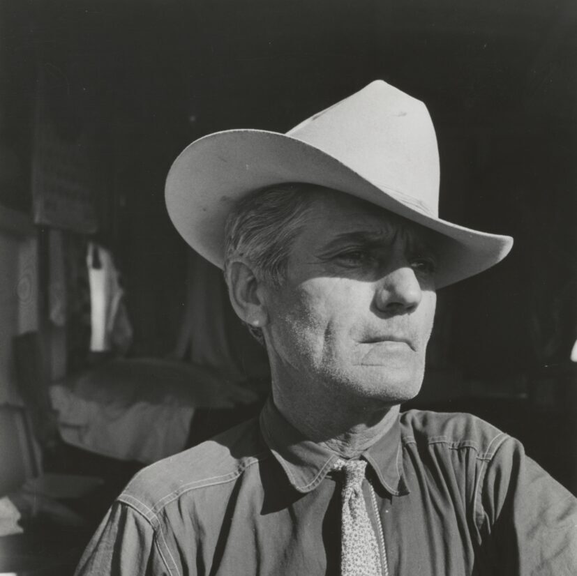 grayscale photography of man wearing cowboy hat and button-up long-sleeved shirt